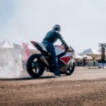 a man riding a motorcycle on top of a dirt road